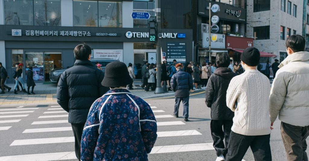 People crossing a bustling street in Seoul, South Korea, on a bright day, showcasing urban life.