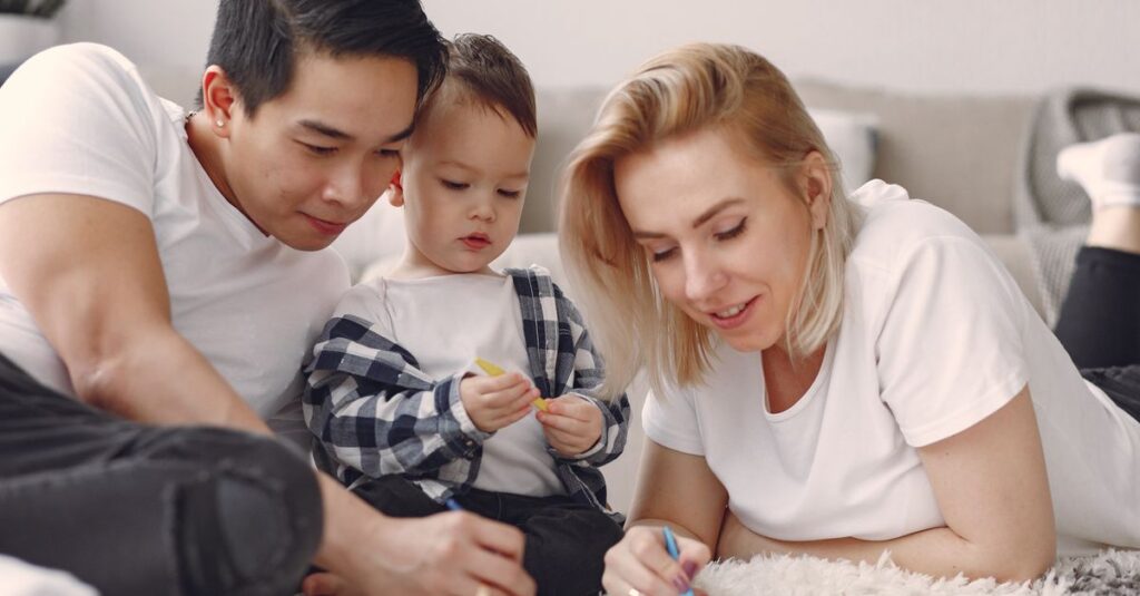 A family enjoys a fun and creative bonding session with drawing activities indoors.