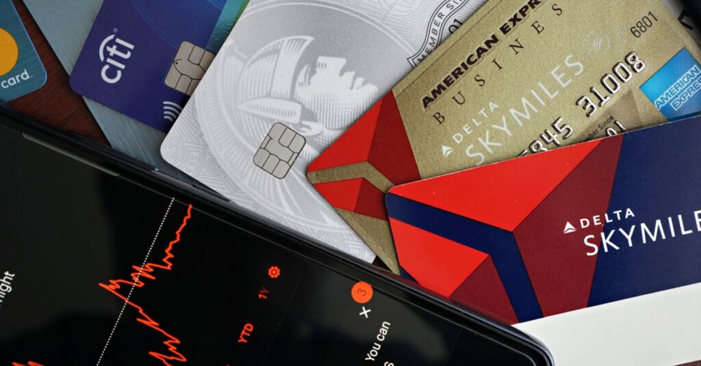 Image showing credit cards and a financial market graph on a smartphone.