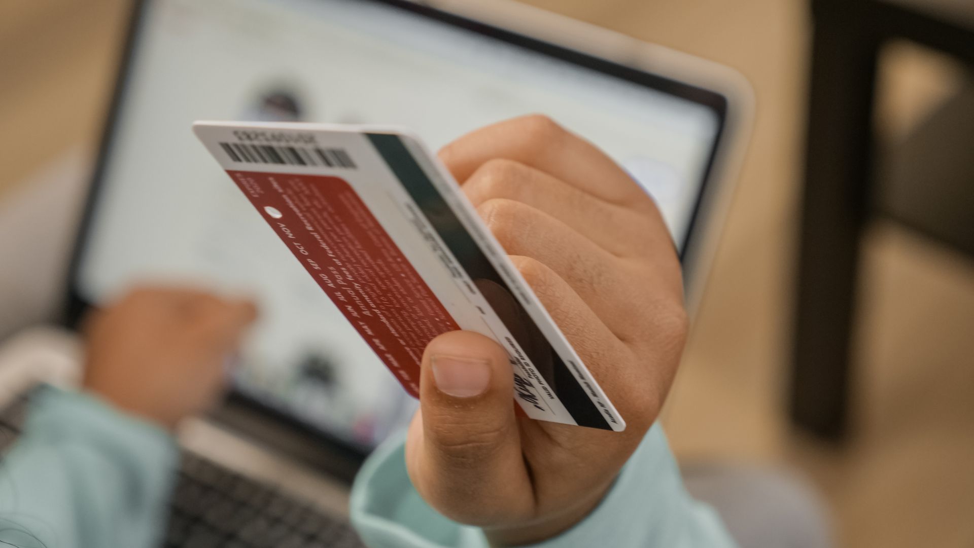 Holding credit card near laptop online application