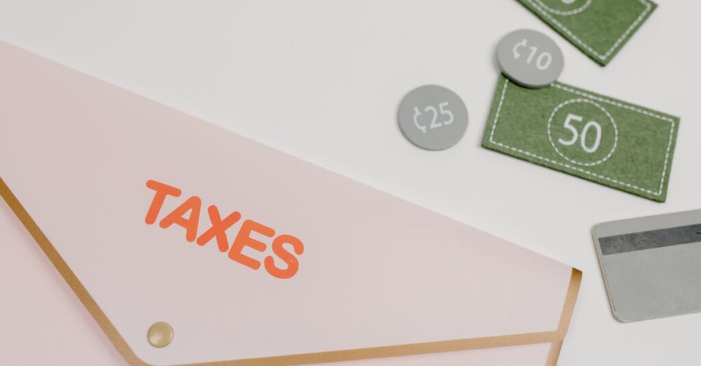 Pink envelope labeled 'TAXES' with play money and card on white background.