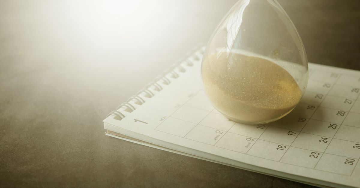 An hourglass on a calendar captures the essence of time management and urgency.
