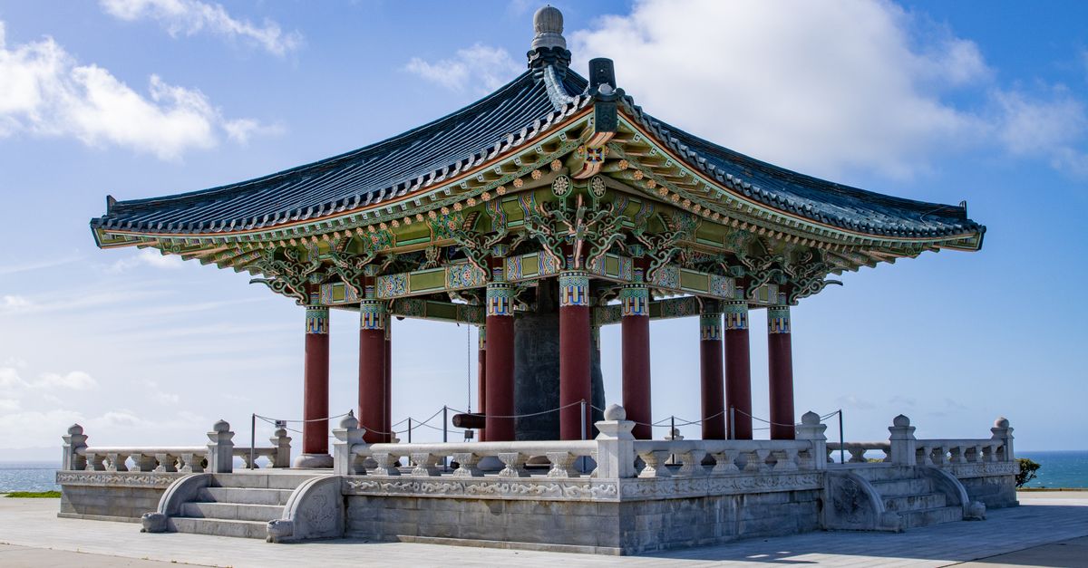 The Korean Friendship Bell pavilion under a clear blue sky in San Pedro, California.