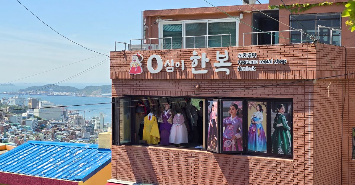 A hanbok rental shop in Busan, South Korea overlooking a vibrant cityscape and the sea.