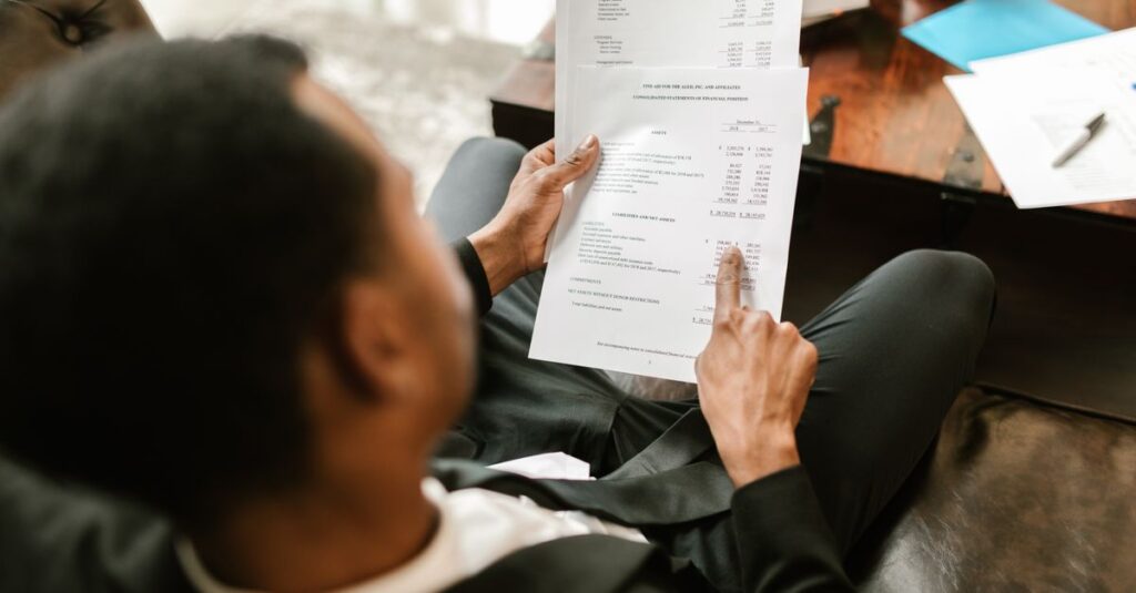 Business professional examining financial documents, focusing on analytics and paperwork in an office setting.