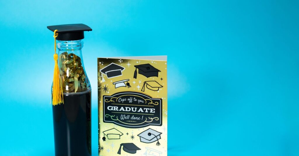 A graduation-themed setup with a bottle and card on a blue background.