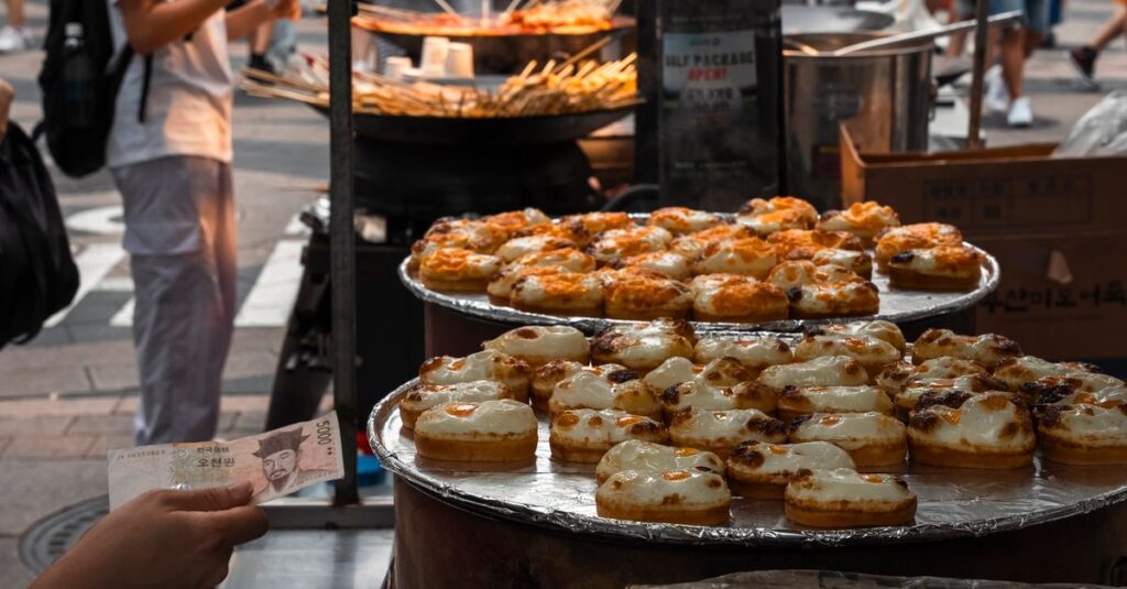 Explore the bustling street food scene in Seoul with delicious pastries on display.