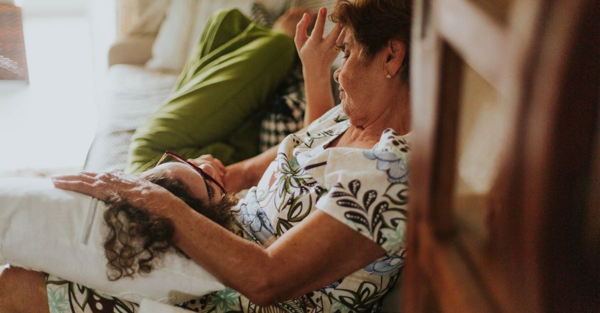 A heartwarming scene of a grandmother and child resting together on a cozy sofa.