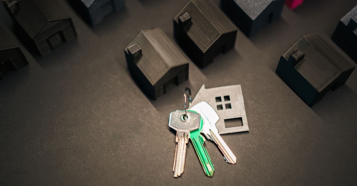 Miniature house models and keys symbolize real estate investment and housing market.